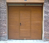 Puerta seccional imitación madera con portón peatonal de gran belleza y compacta,su portón hace accesible la entrada desde el exterior con llave.